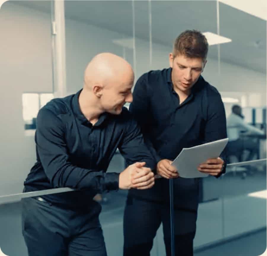 two men looking at a piece of paper