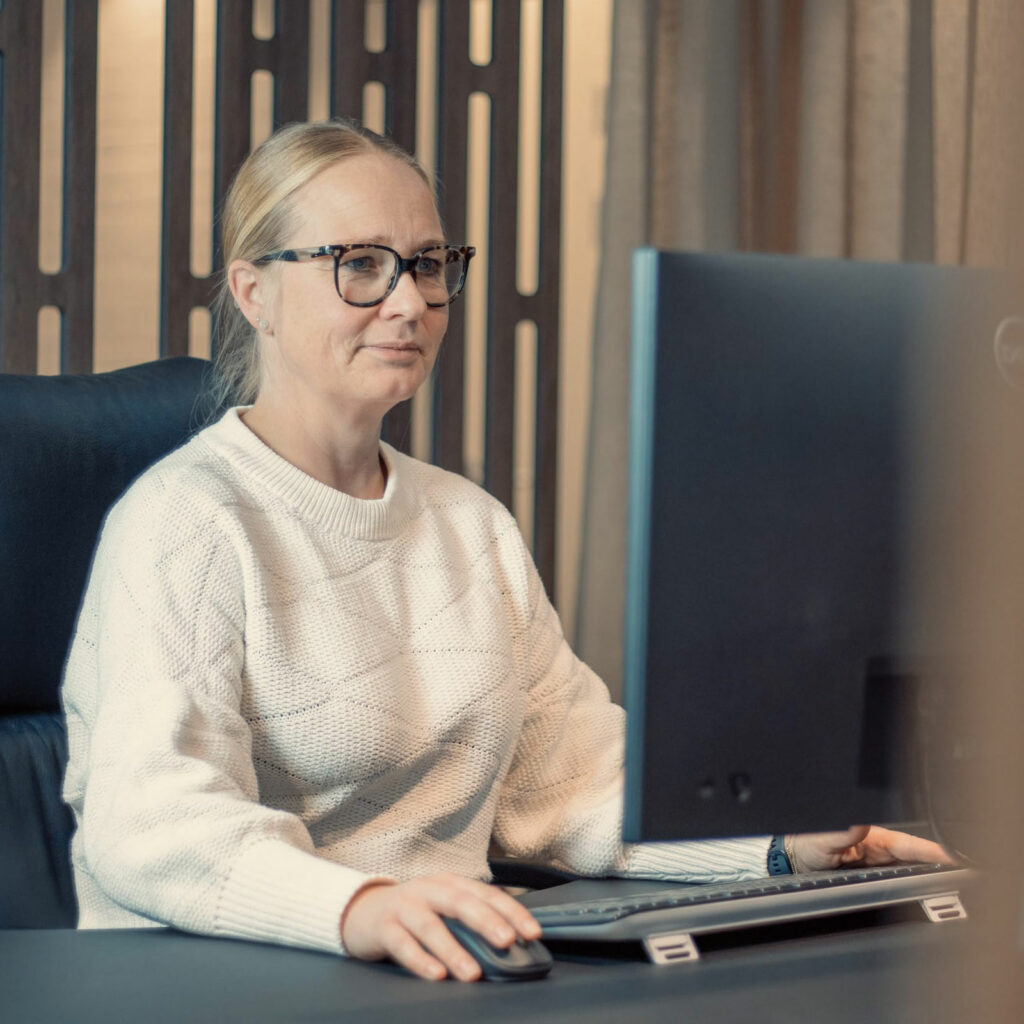 a woman sitting at a desk with a computer